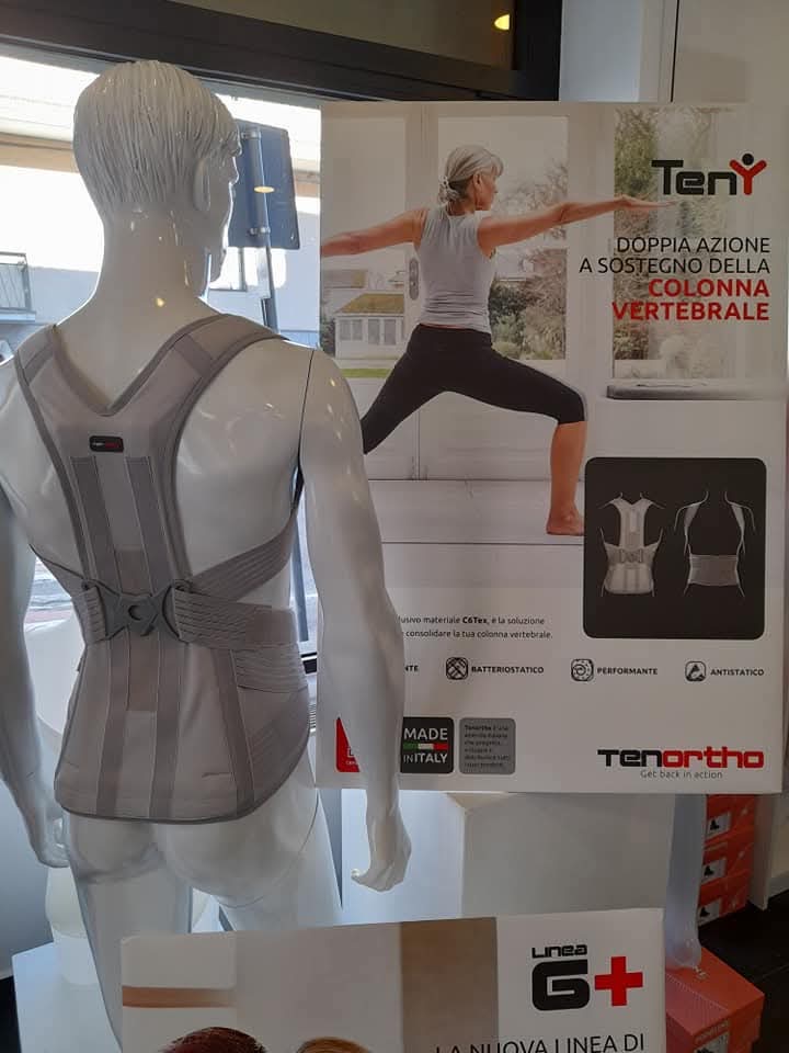 Manichino con busto ortopedico per il sostegno della colonna vertebrale, esposto in negozio con poster promozionale